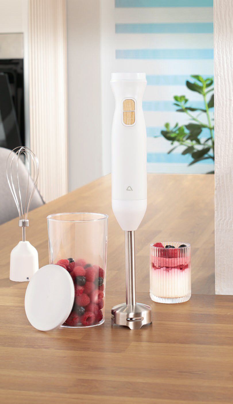 Mixer vertical Ambiano de 800W de culoare alba pe o masa din lemn alaturi de un pahar gradat cu fructe si un accesoriu tel